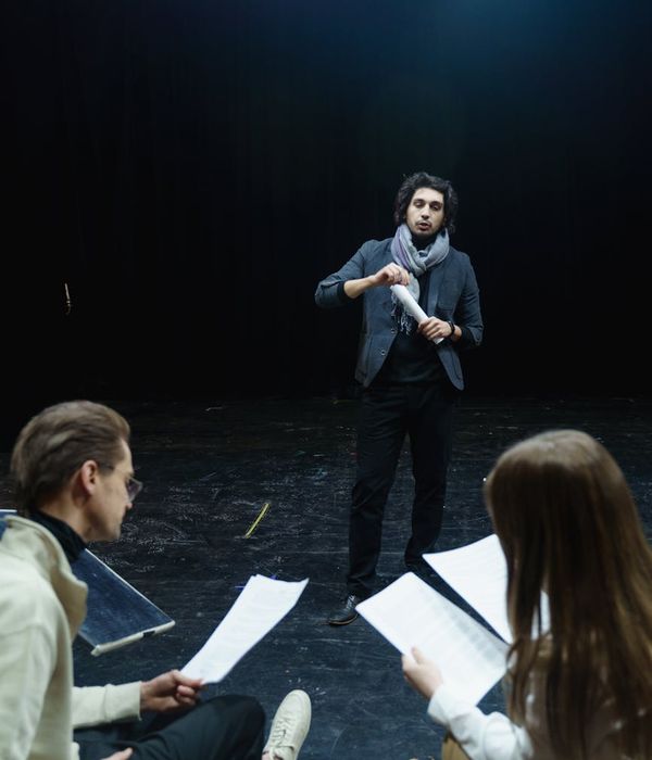 A man performing a controlled strength exercise in a dark room with mint colored ambient light.