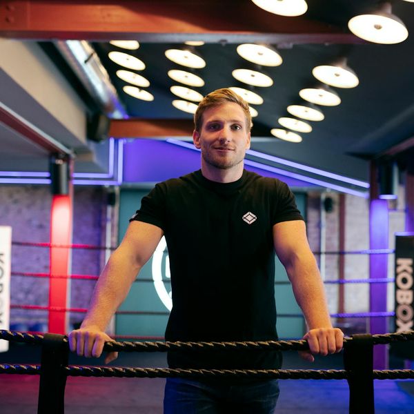 Man in a focused state, preparing for a physical exercise, with abstract light trails around.